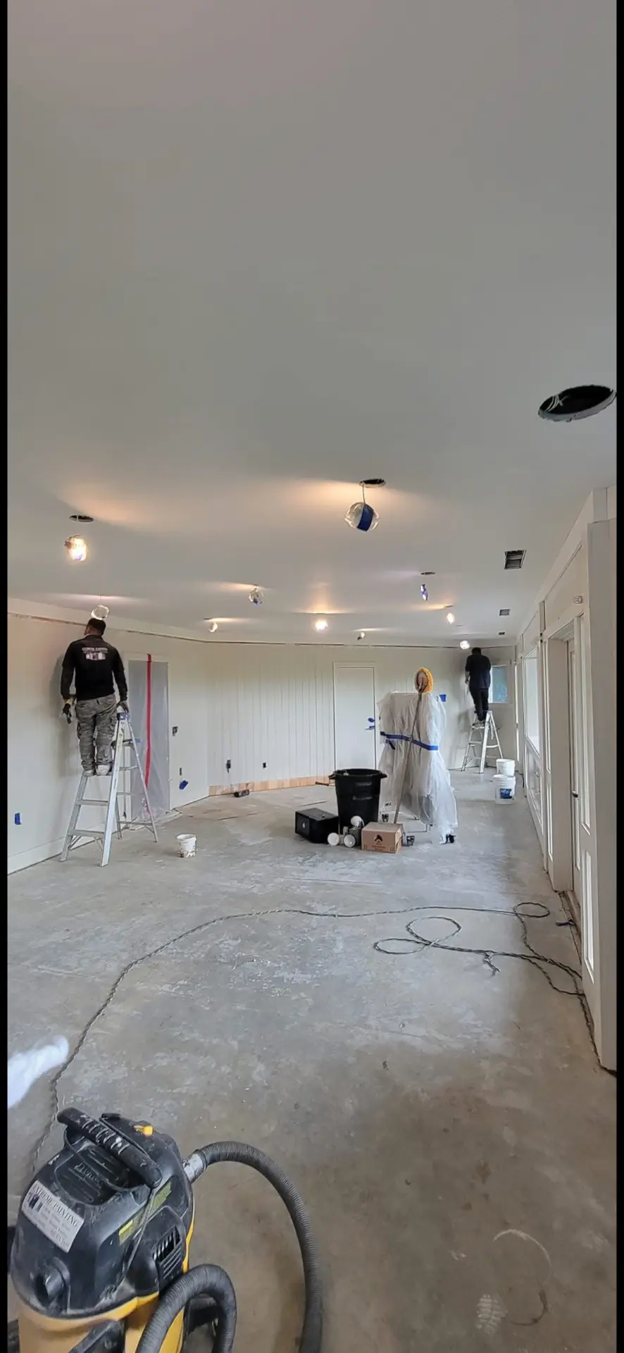 Extreme Painting crew cutting in walls and ceilings inside a large room